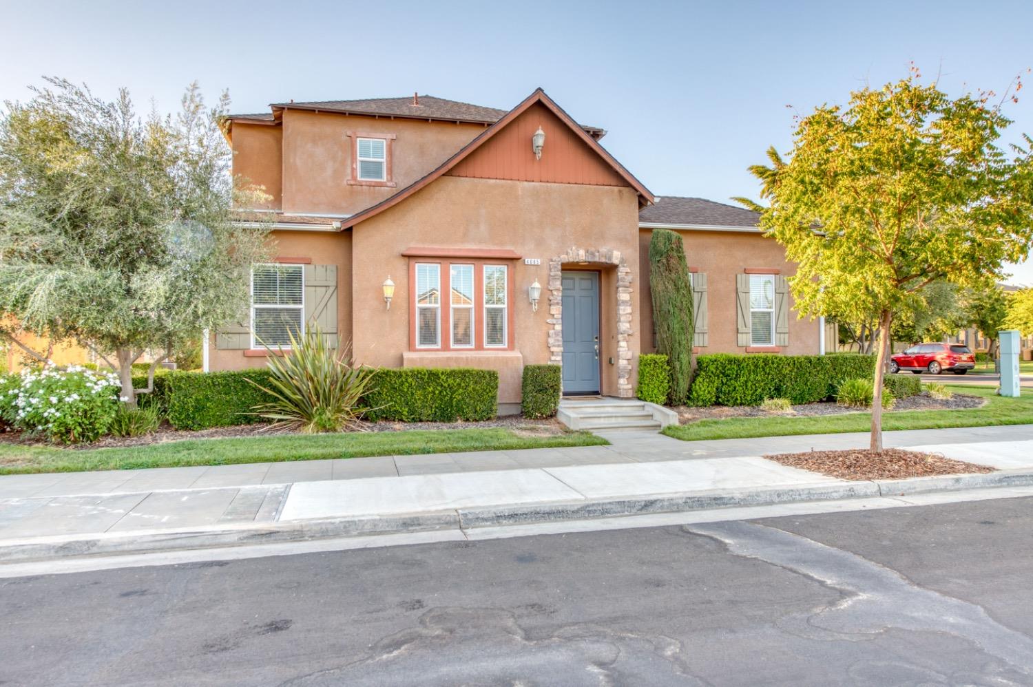 4085 Harlan Ranch Boulevard Clovis, CA 93619 - Photo 2 of 27 a front view of a house with a yard and a garage