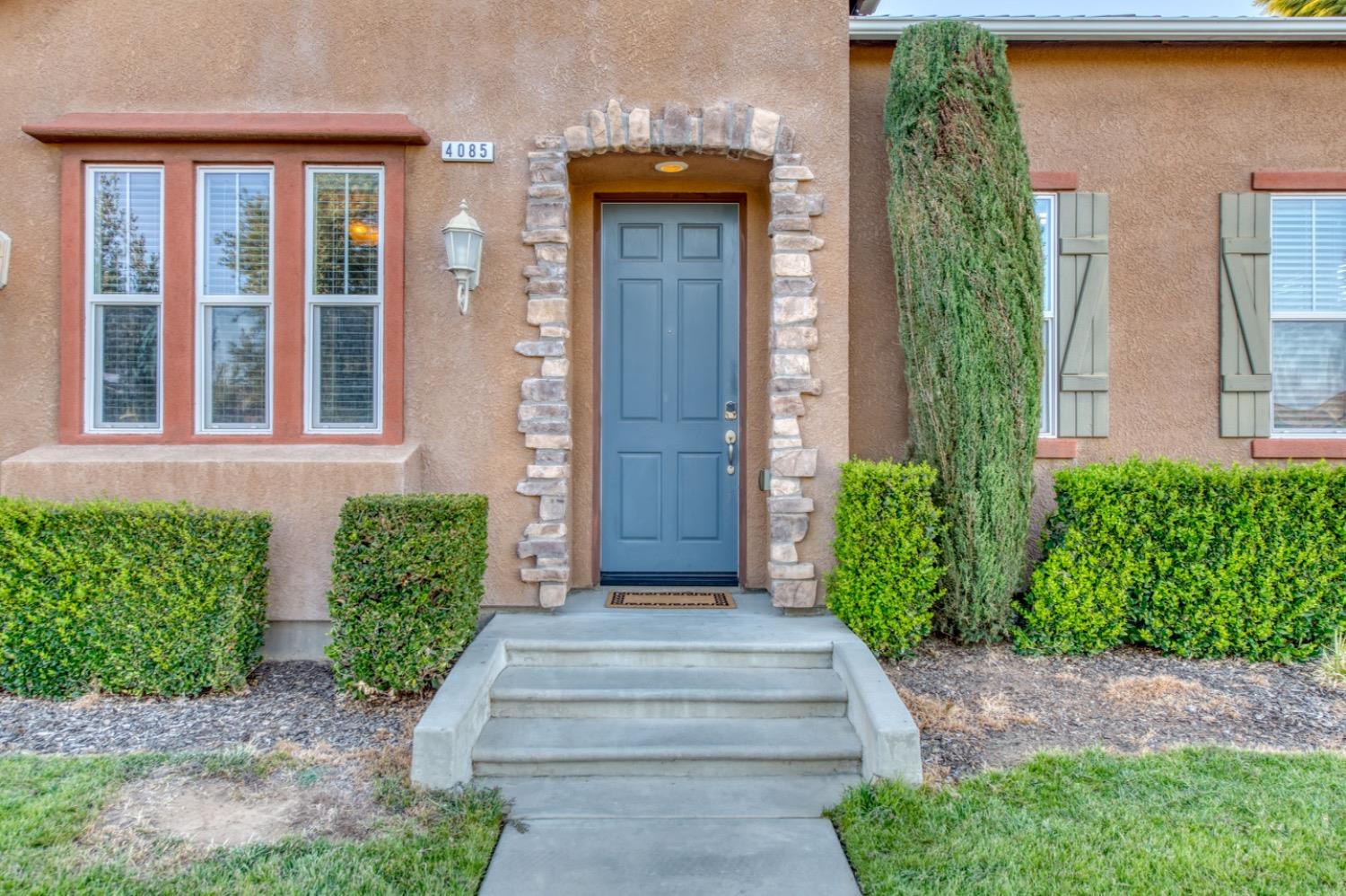 4085 Harlan Ranch Boulevard Clovis, CA 93619 - Photo 4 of 27 front view of a house with a large windows and plants