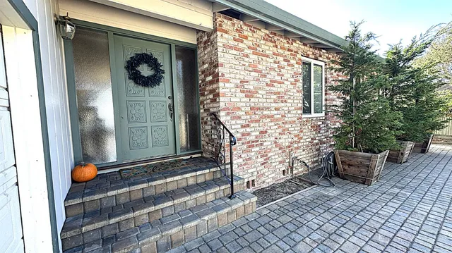 a front view of a house with outdoor seating and a potted plant