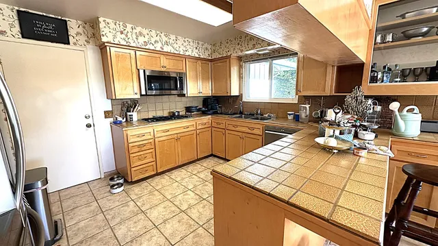 a kitchen with stainless steel appliances kitchen island granite countertop a sink and cabinets