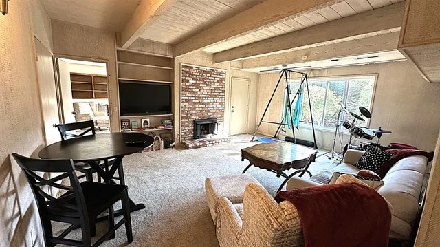 a living room with furniture a flat screen tv and a large window