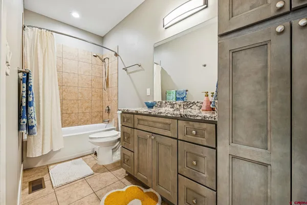 a bathroom with a granite countertop sink toilet and shower