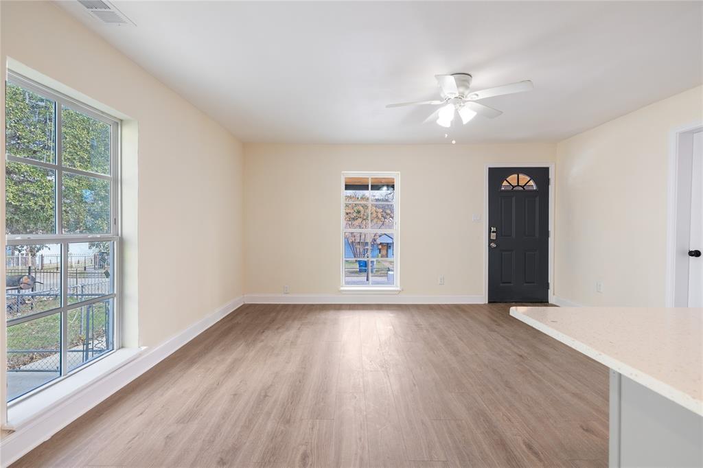 1715 Navaro Street Dallas, TX 75208 - Photo 11 of 33 Unfurnished living room with light wood-style floors and a ceiling fan