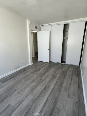 an empty room with wooden floor and closet