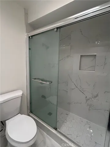 a white toilet next to a bathroom