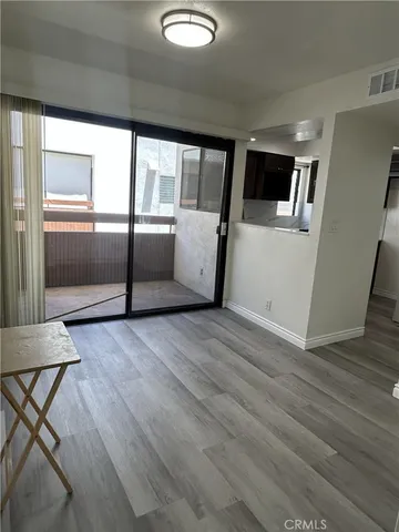 a view of a kitchen with furniture and wooden floor