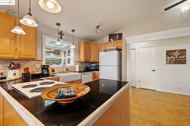 a kitchen with stainless steel appliances granite countertop a sink a stove and a refrigerator