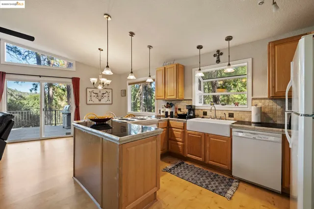 a kitchen with kitchen island a sink stove and refrigerator