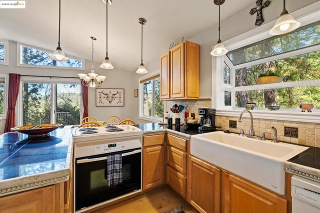 a kitchen with stainless steel appliances granite countertop a stove a sink and a wooden floor