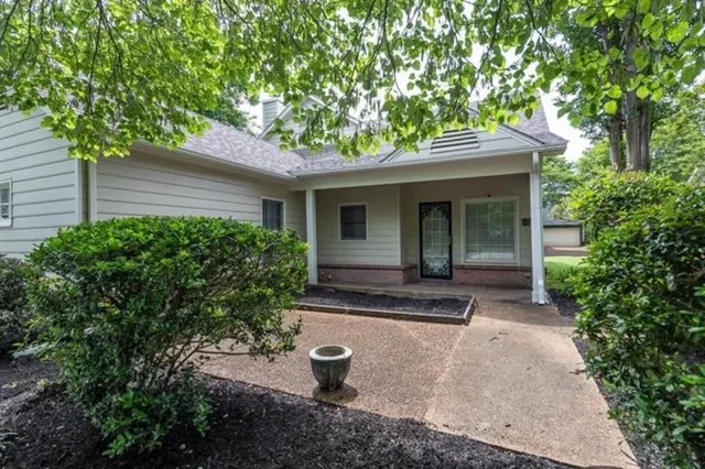 a view of a house with backyard and a garden