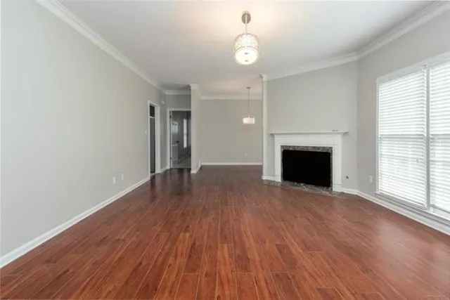 a view of empty room with wooden floor and fireplace