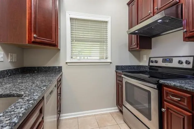 a kitchen with granite countertop a stove and a sink