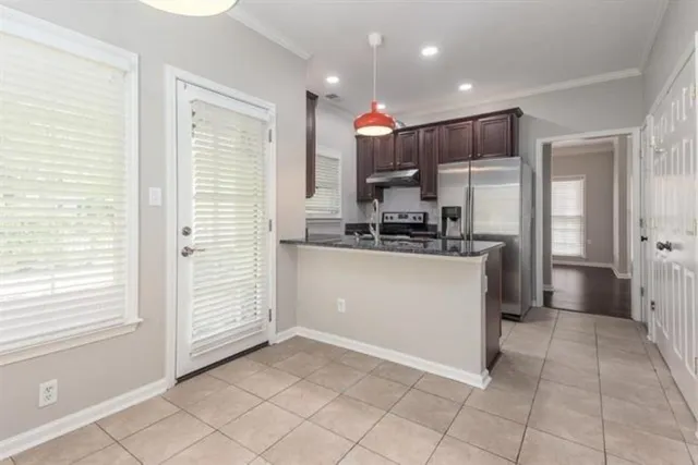 a kitchen with kitchen island granite countertop a refrigerator and a sink
