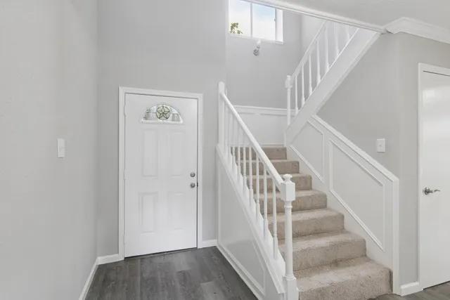 a view of staircase with wooden floor and white walls