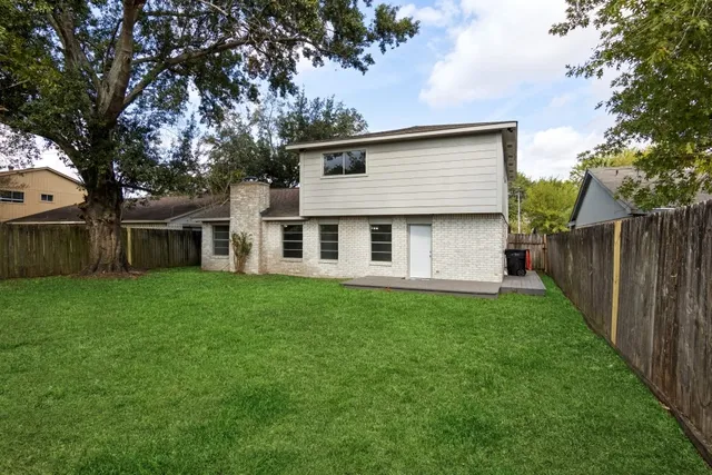 a view of a yard with a house and a large tree