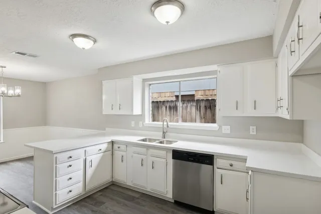 a kitchen with cabinets appliances a sink and a window