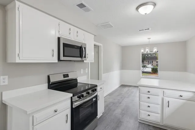 a kitchen with granite countertop white cabinets and white appliances
