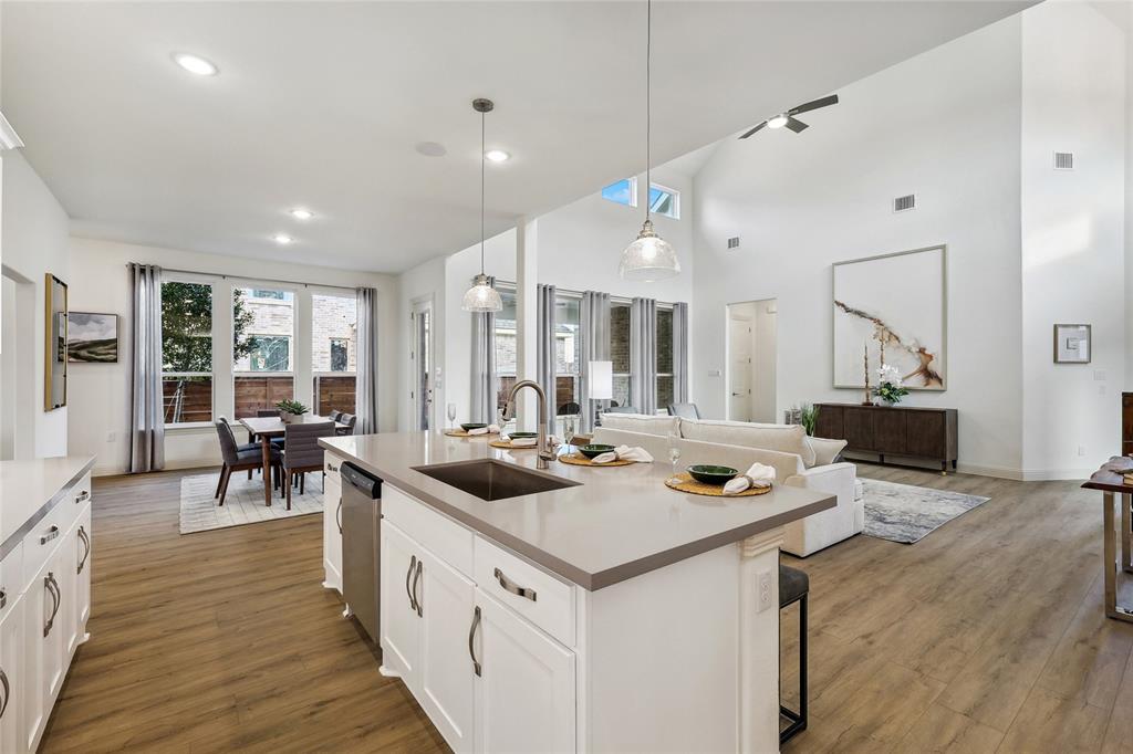1604 Casting Ridge Mesquite, TX 75181 - Photo 15 of 38 Open-concept living space featuring a central island with a built-in sink and seating, wood-finish flooring, recessed lighting, and a dining area with expansive windows
