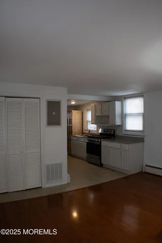 a kitchen with stainless steel appliances wooden floor and window