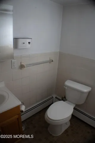 a white toilet sitting next to a white sink and vanity