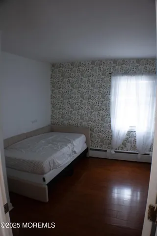 a room with a wooden floor and a window