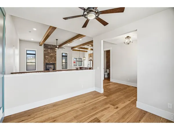 a view of an empty room with window and wooden floor