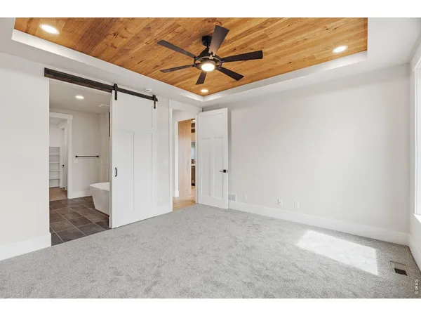 a view of a hallway with a ceiling fan and wooden floor