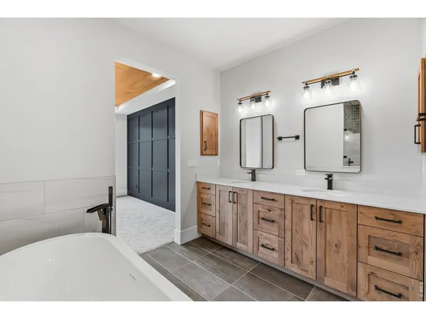 a spacious bathroom with a double vanity sink a mirror and a