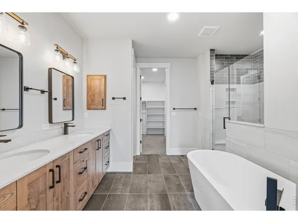 a bathroom with a double vanity sink a large mirror and a shower