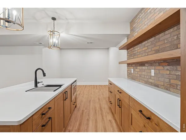 a kitchen with a sink a counter space and wooden floor