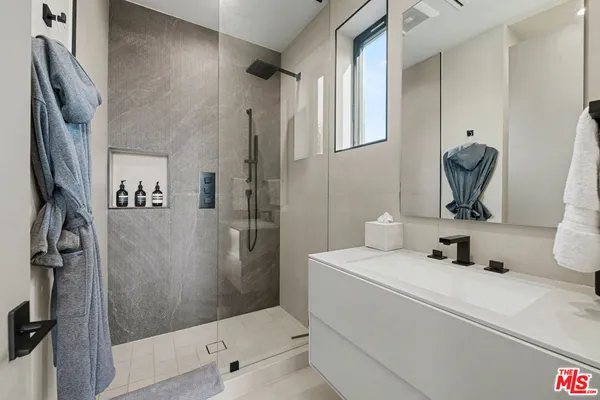 a bathroom with a sink a toilet a mirror and shower