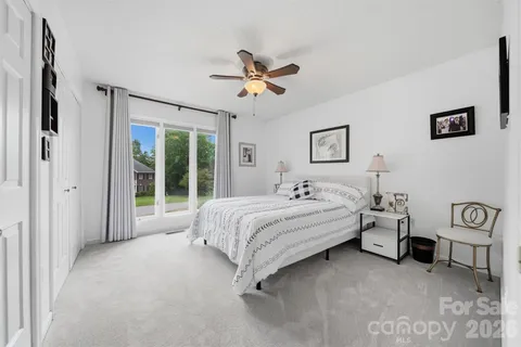 a spacious bedroom with a bed and a chandelier