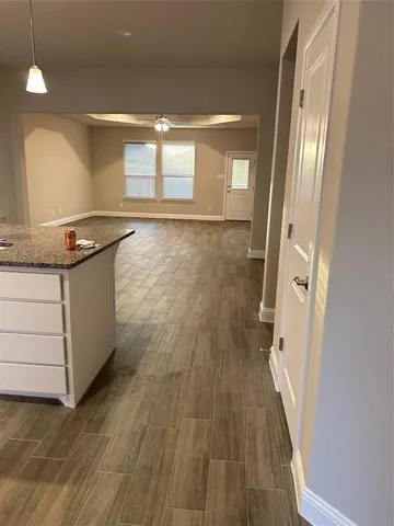 a open kitchen with a sink and wooden floor