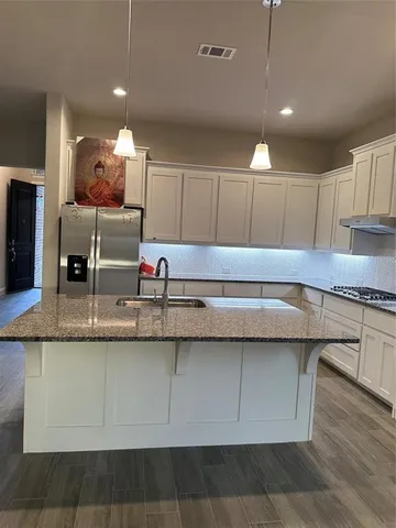 a kitchen with granite countertop a sink and cabinets