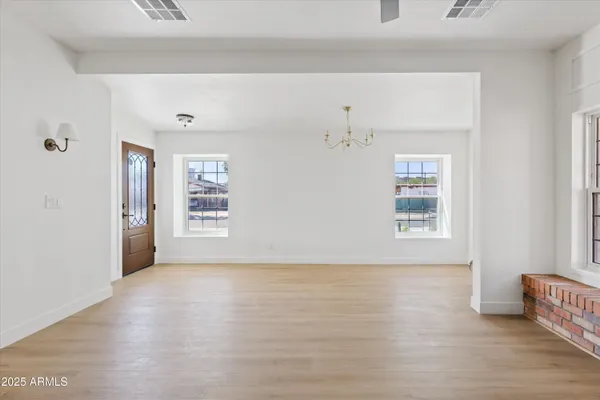 a view of an empty room with a window and fireplace