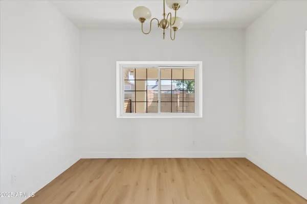 a large kitchen with a refrigerator a sink dishwasher a oven with white cabinets and wooden floor