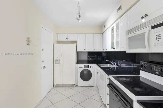 a kitchen with a refrigerator and a stove top oven