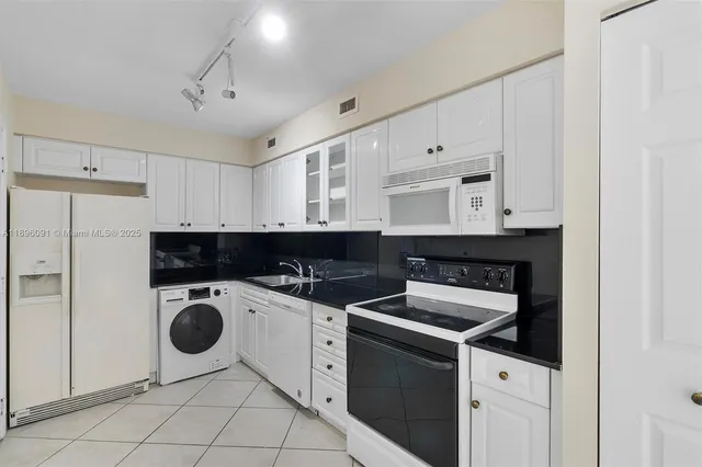 a kitchen with a sink a stove and cabinets