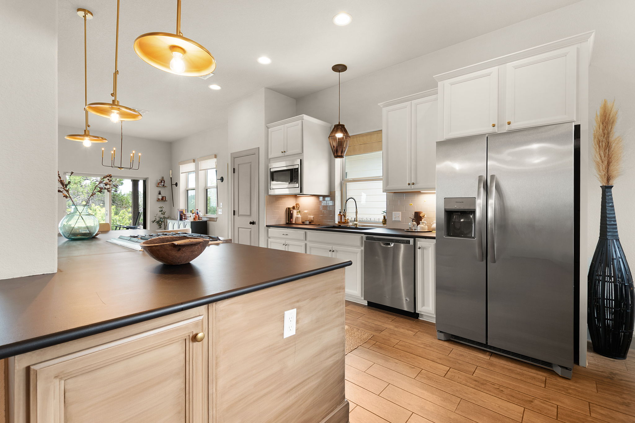 155 Balcones Ridge Way Bertram, TX 78605 - Photo 11 of 37 The contemporary kitchen features an inviting island, pendant lighting, and abundant natural light.