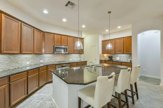 a kitchen with granite countertop sink cabinets and stainless steel appliances