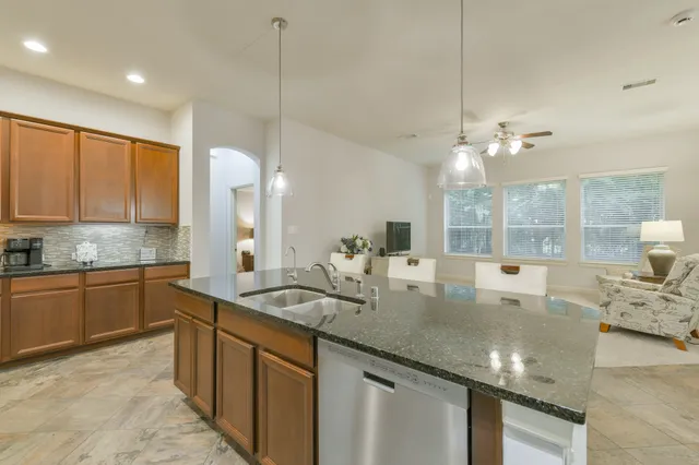 a kitchen with a sink a counter and chairs