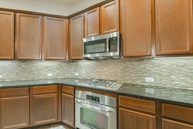 a kitchen with stainless steel appliances granite countertop a sink and cabinets