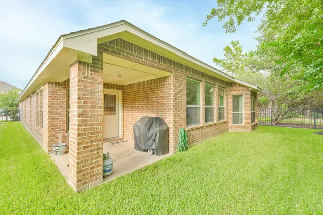 a view of a house with backyard and a tree