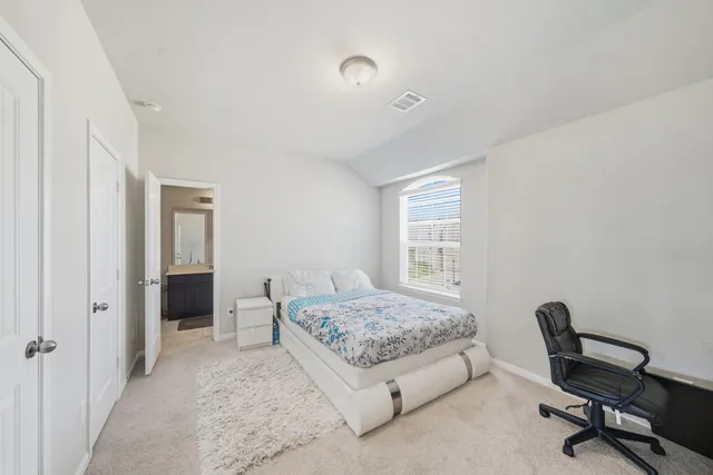 a bedroom with a bed and a desk