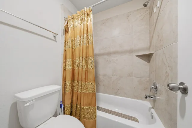 a white toilet sitting next to a bath tub