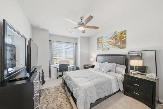 a bedroom with a bed a large window and flat screen tv