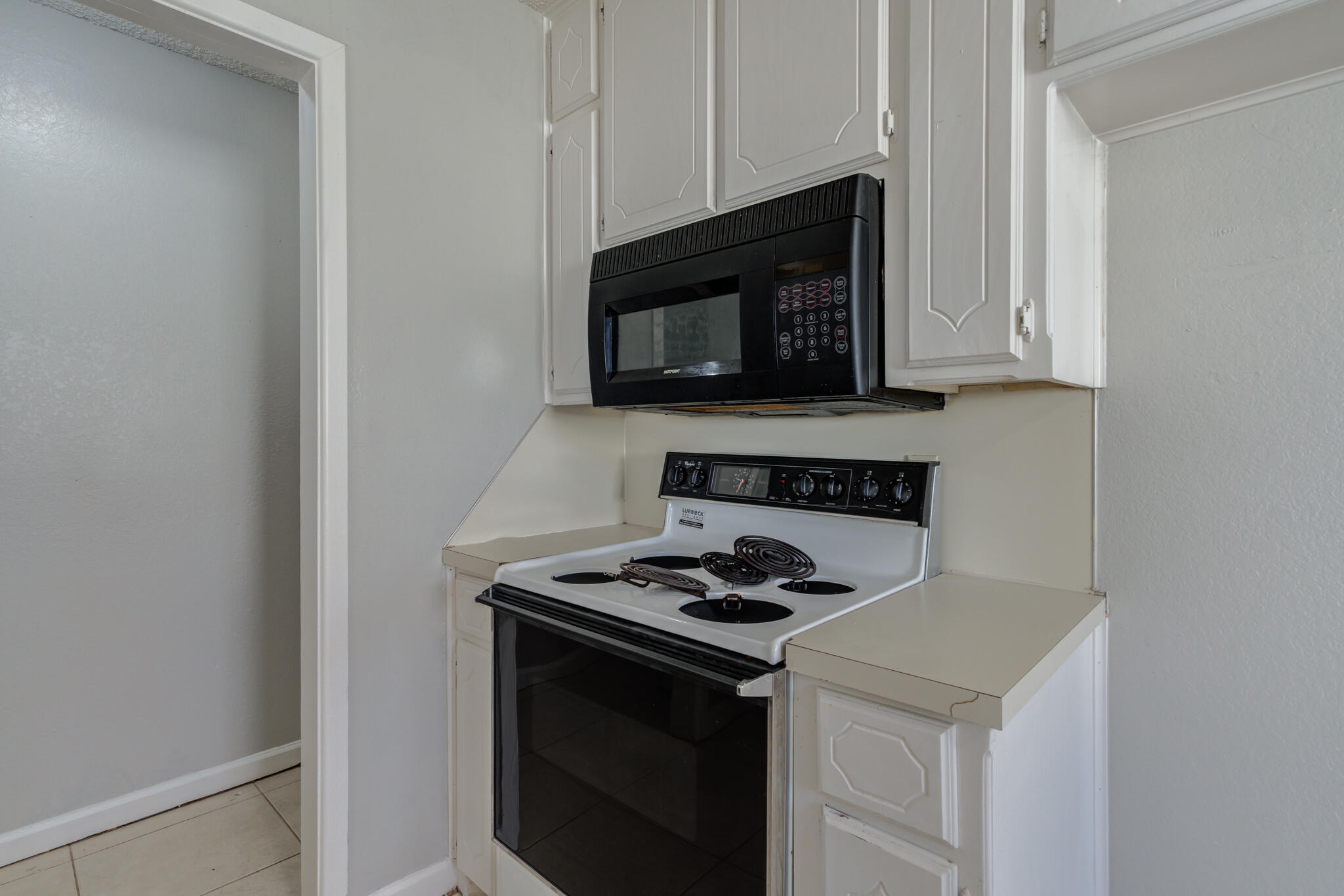 6212 22nd Street Lubbock, TX 79407 - Photo 12 of 24 a kitchen with microwave cabinets and stove top oven