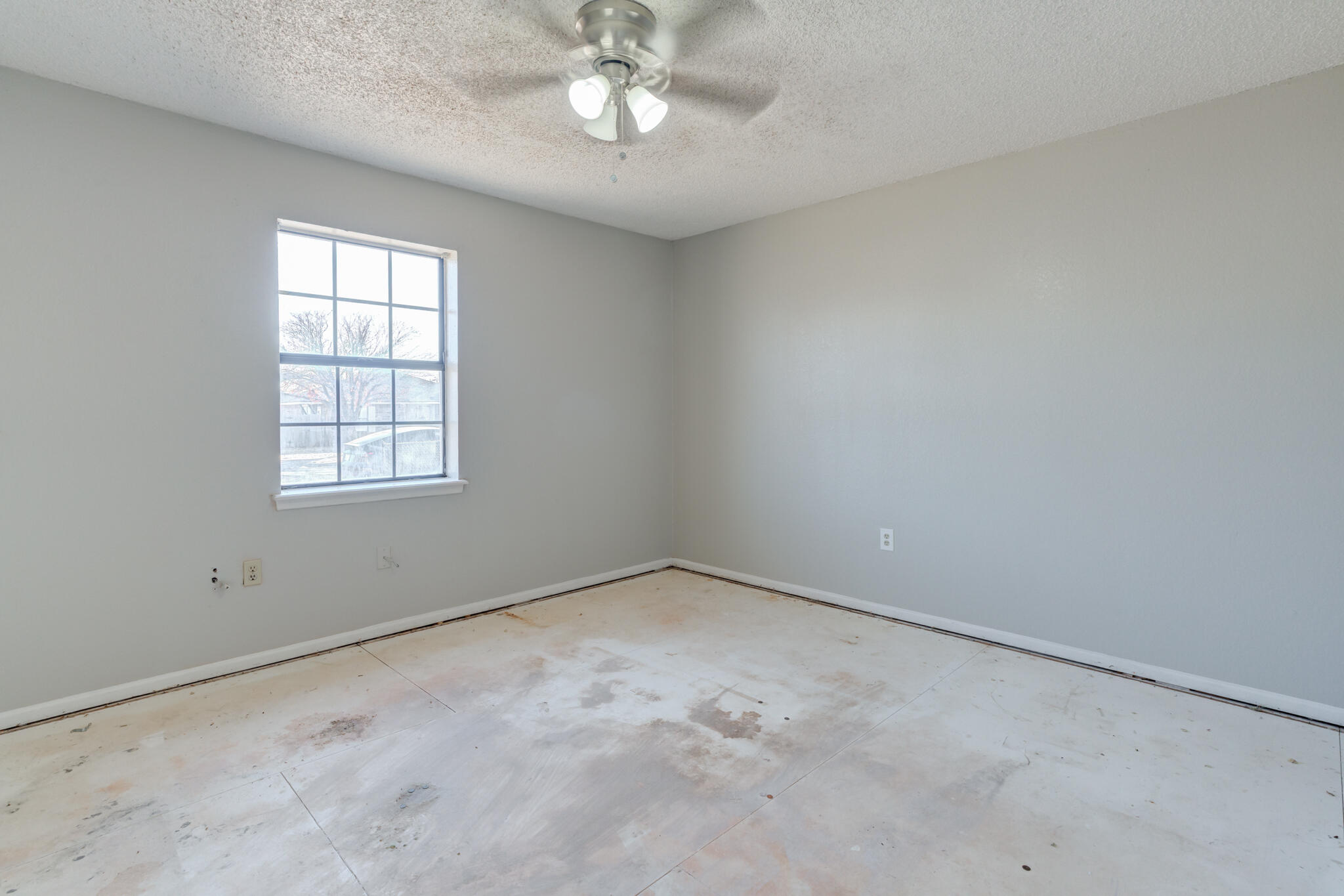 6212 22nd Street Lubbock, TX 79407 - Photo 16 of 24 an empty room with a chandelier fan and windows