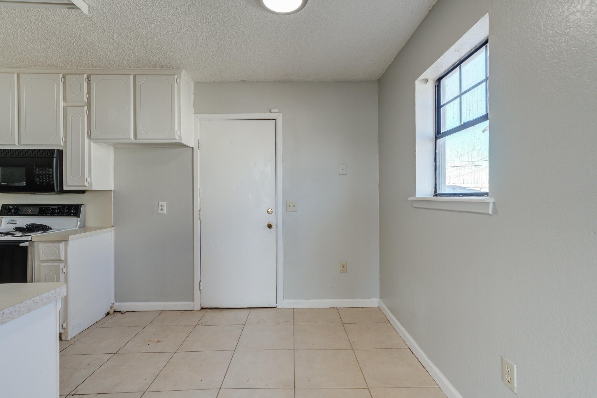 6212 22nd Street Lubbock, TX 79407 - Photo 9 of 24 a view of a kitchen with dishwasher and white cabinet with wooden floor