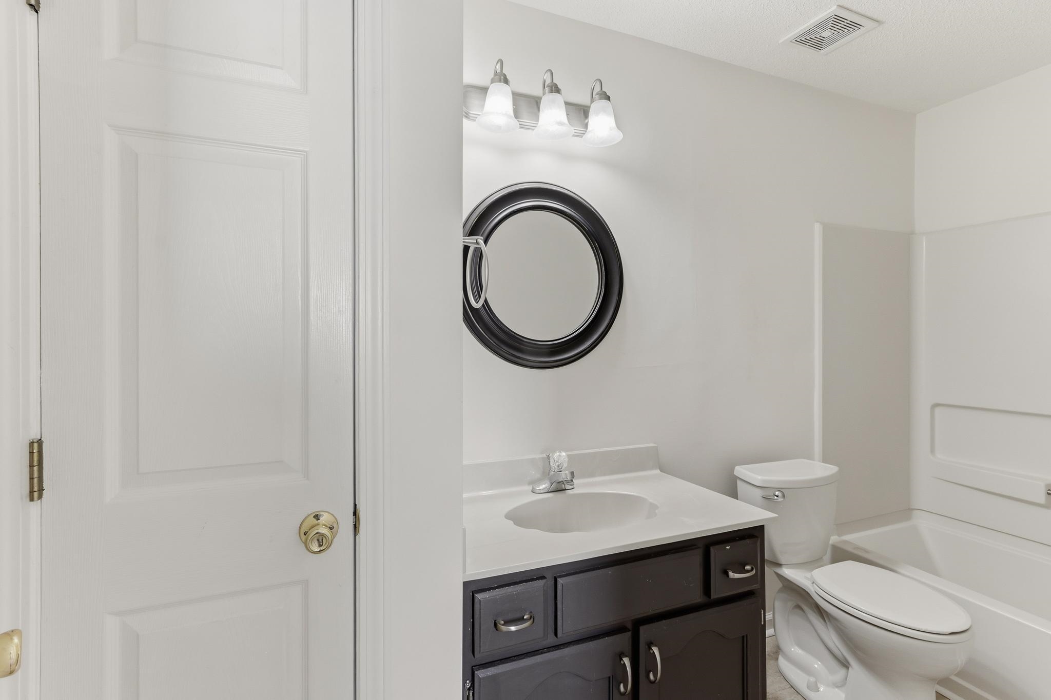 1066 Whitten Road Cordova, TN 38018 - Photo 16 of 30 a bathroom with a sink a toilet and a mirror
